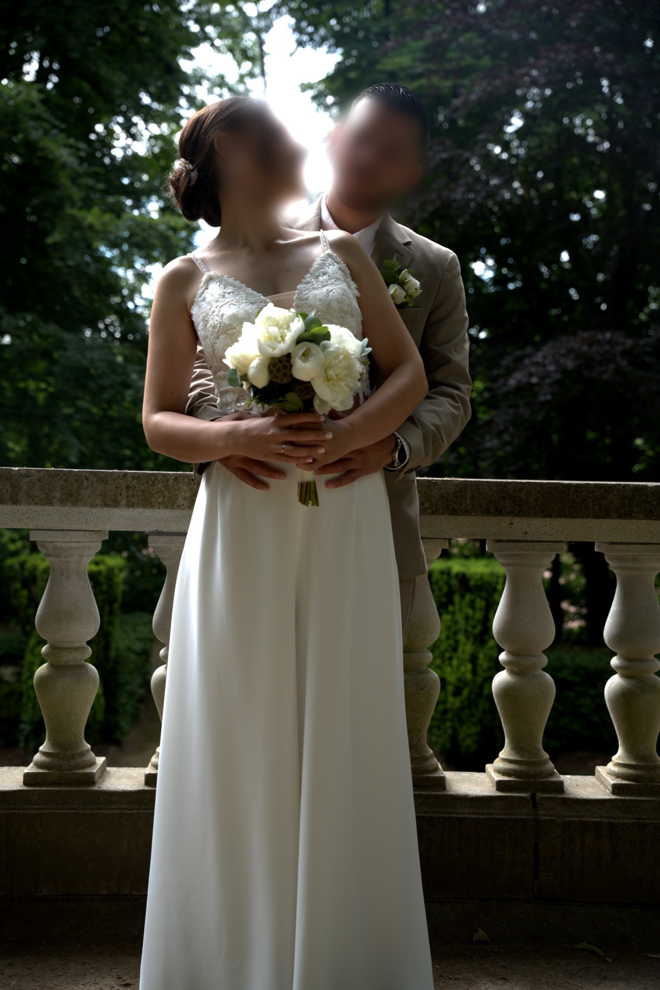 Les mariés enlacés, la mariée tenant son bouquet